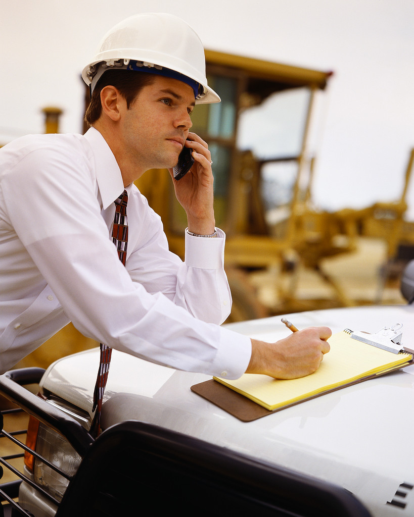 Businessman with Cell Phone and Clipboard