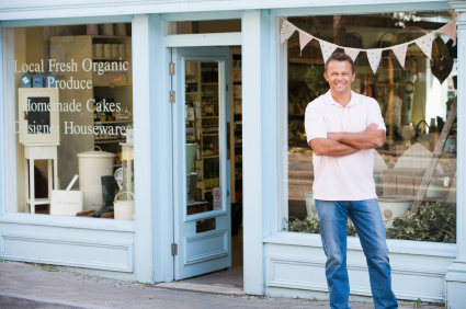 Man standing in front of organic food store smiling self-employed