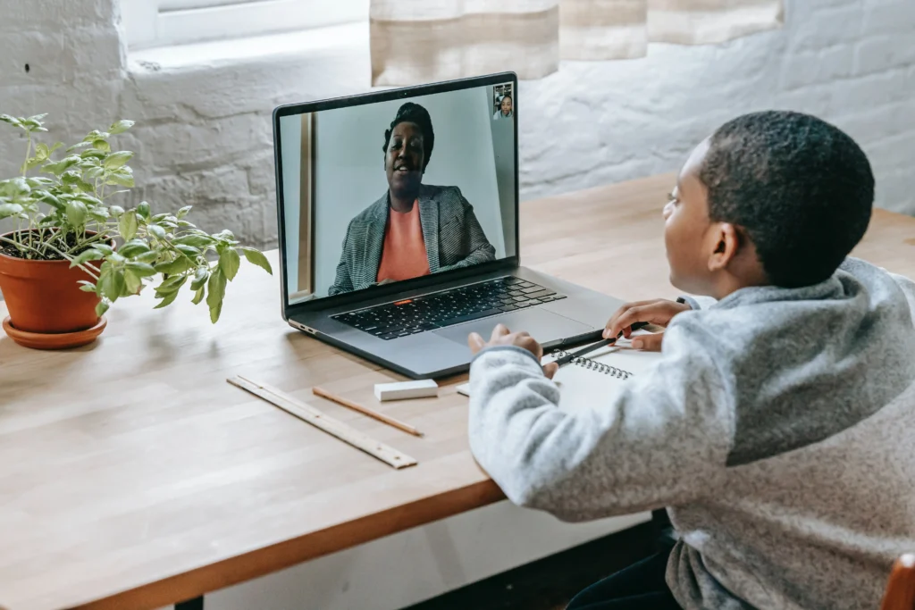 A boy talking with a teacher online