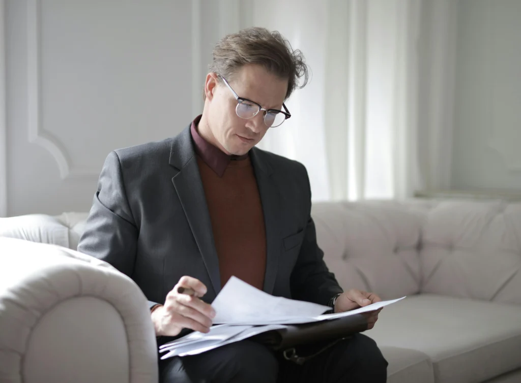 executive background check: reading papers on couch