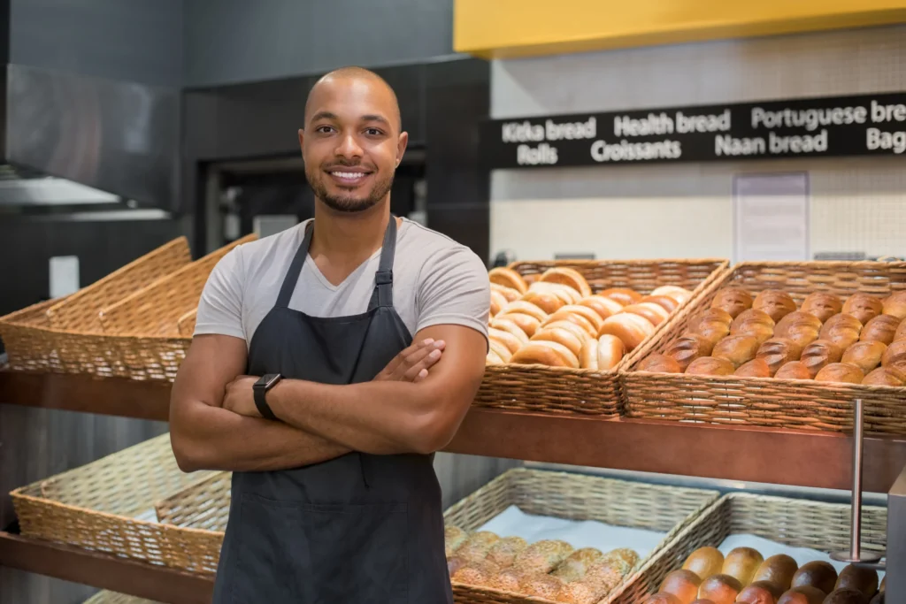 man with baked goods in bakery